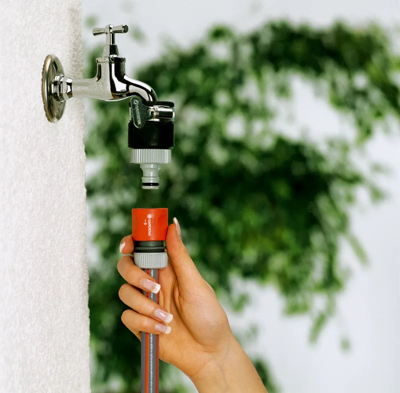 Prise d'eau voleuse Gardena serrée à la main sur un robinet lisse