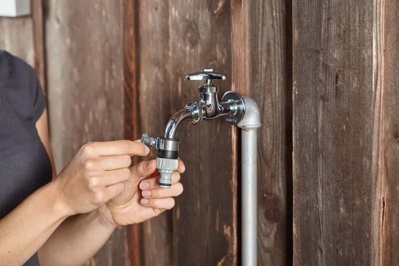 Prise d'eau voleuse Gardena fixée sur un robinet de jardin